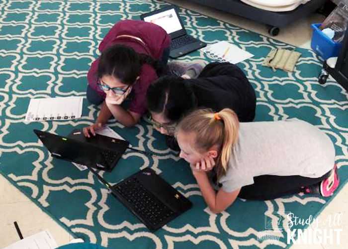 students working on a digital escape room on the floor